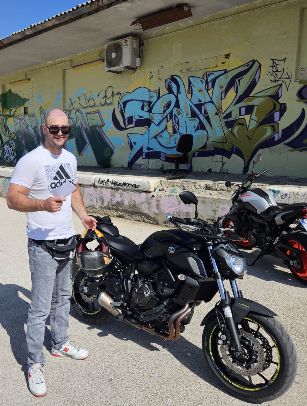 Motociklist s A kategorijom ispred zida s grafitima u Splitu